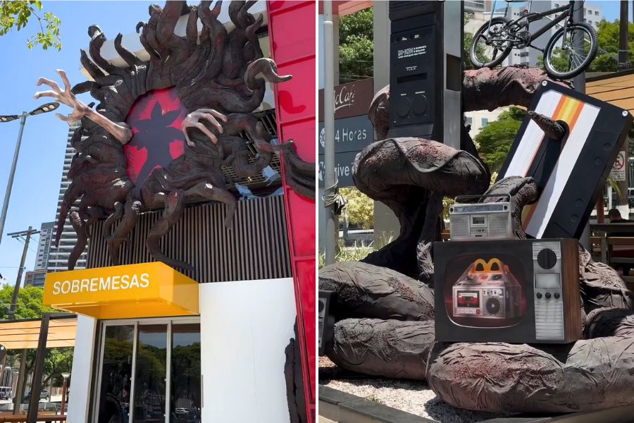 Fachada do McDonald’s em São Paulo decorada com elementos inspirados no Mundo Invertido de Stranger Things, incluindo tentáculos, mãos monstruosas, objetos retrô e esculturas temáticas.