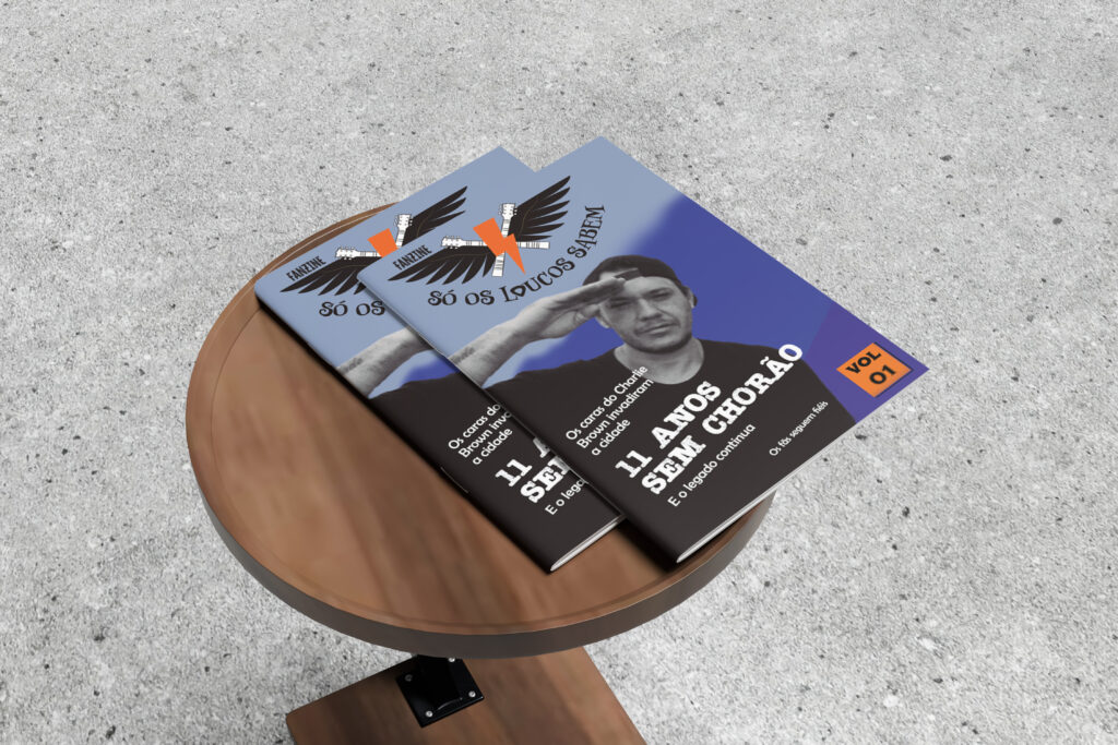Dois exemplares do fanzine “Só os Loucos Sabem” sobre uma mesa de madeira, com a capa em homenagem aos 11 anos sem Chorão.
